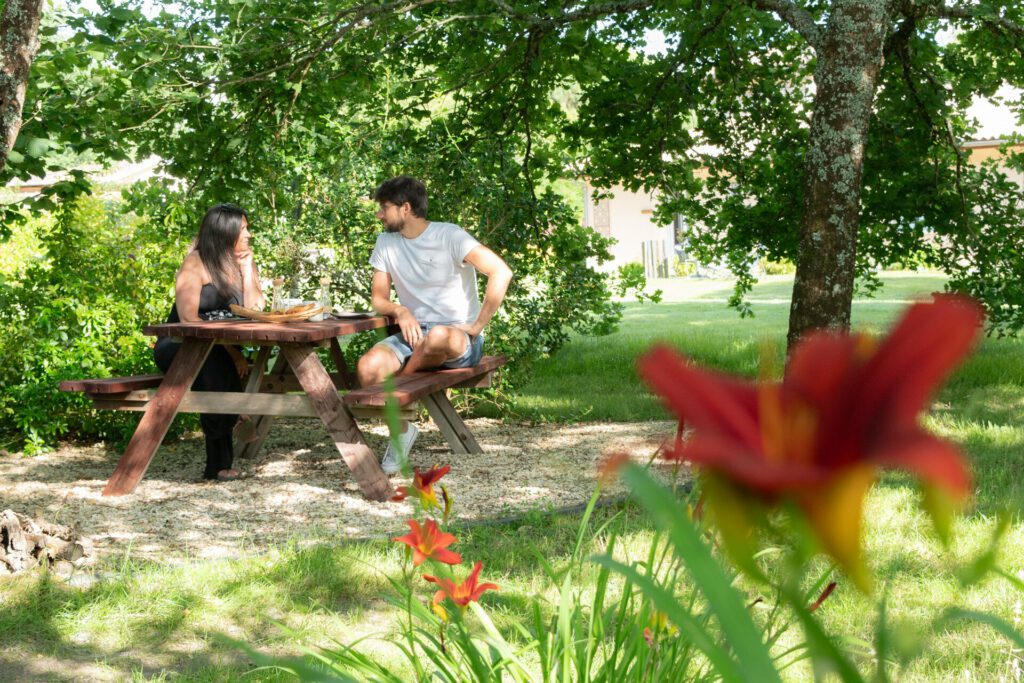 Couple partageant un moment dans le jardin à l’Escale Sud Gironde près de Bordeaux